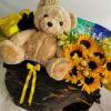 Detalle de peluche y ramo de girasoles en caja negra marmoleada