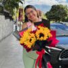Ramo floral de girasoles y rosas en manos de una mujer feliz mujer sosteniendo ramo de girasoles y rosas