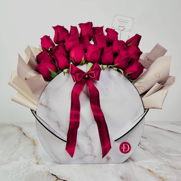 arreglo con rosas rojas naturales y cinta burdeos en caja mármol