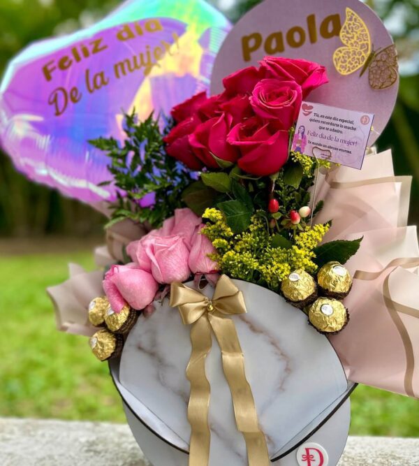 vista lateral de cesta con chocolates Ferrero Rocher y rosas frescas