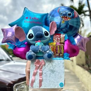 Peluche azul con decoración de globos y chocolates en caja blanca