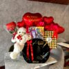 Vista completa del regalo con chocolates importados, peluche y globo corazón