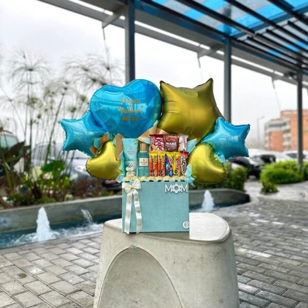 Primer plano del arreglo con splash Seaside Surf, chocolates Ferrero y 8 golosinas venezolanas.