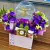 Regalo con flores frescas y globos para el Día de las Madres Arreglo floral violeta con globos y dulces para mamá
