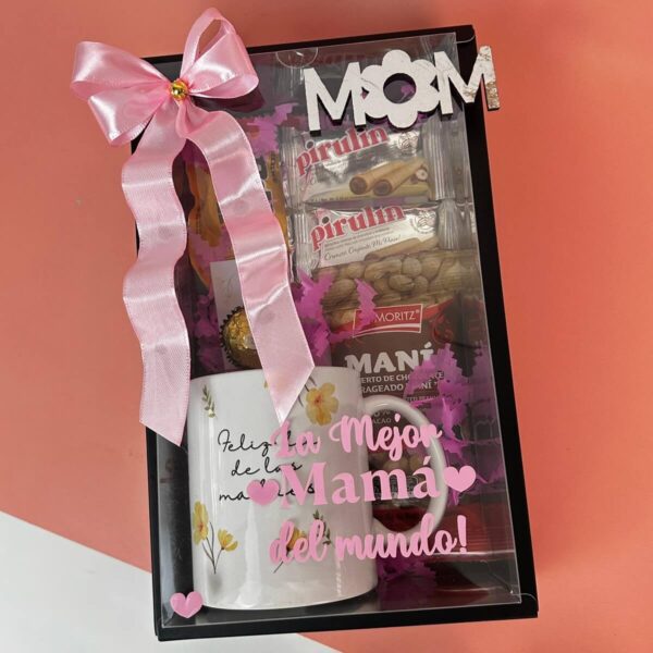 Caja de regalo abierta con taza, chocolates y mensaje con flores